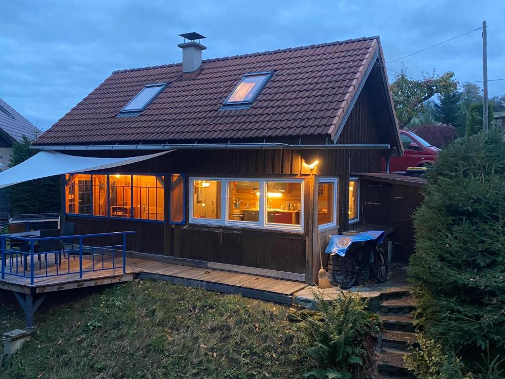 a small house with a roof on a deck at Kletterhütte Sächsische Schweiz in Hohnstein