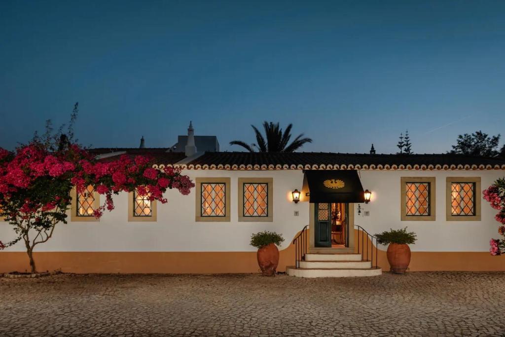 a white building with flowers in front of it at Liberal Wing Villa in Portimão
