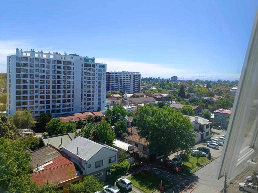 an aerial view of a city with a tall building at Habitaciones en Departamento Centro de Chillan in Chillán