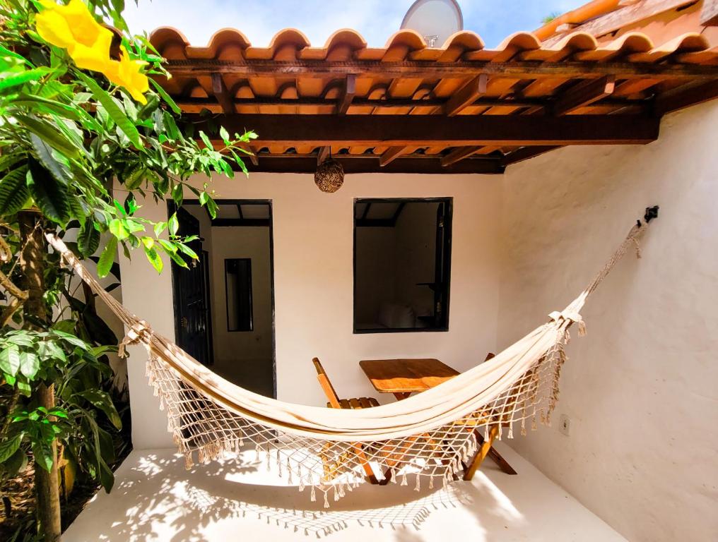 a hammock on the porch of a house at Pousada Vilarejo in Caraíva