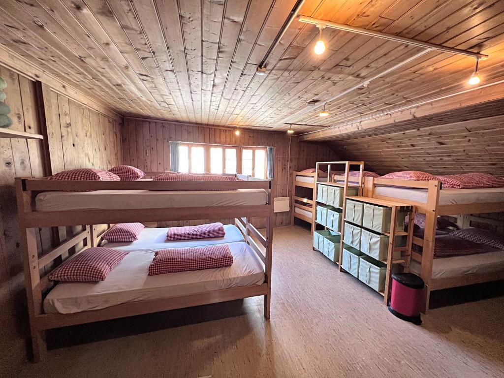 a room with three bunk beds in a cabin at Jugendherberge Hospental in Hospental