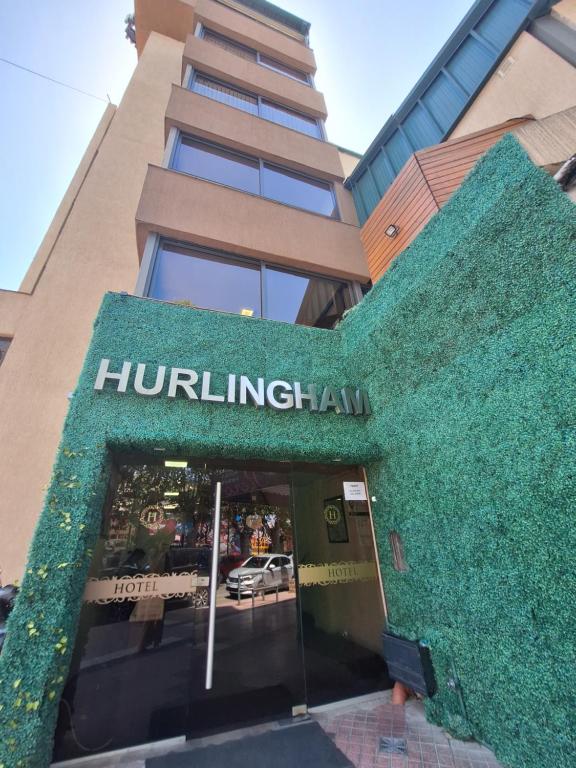un edificio con un cartel en la parte delantera en Hotel Hurlingham en Villa Carlos Paz