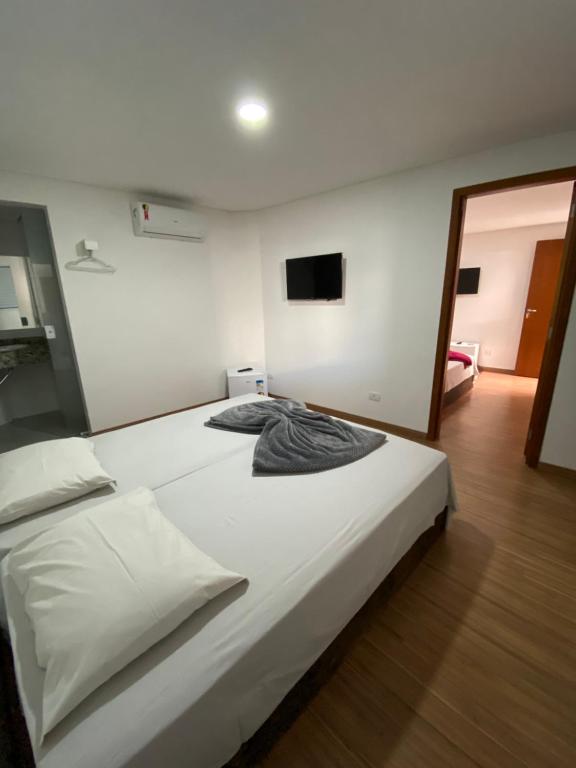 アグアス・デ・サン・ペドロにあるPousada Vila Barboza - Próxima ao Thermas Water Parkのベッドルーム1室(白い大型ベッド1台付)