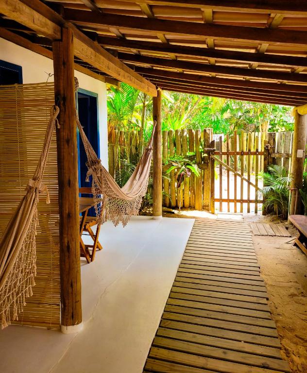 a hammock on the porch of a house at Pousada Vilarejo in Caraíva