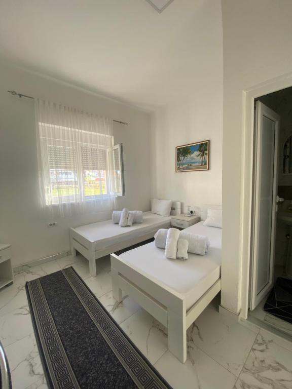 Vila Safir في لوزنيكا: غرفة بيضاء بسريرين ونافذة