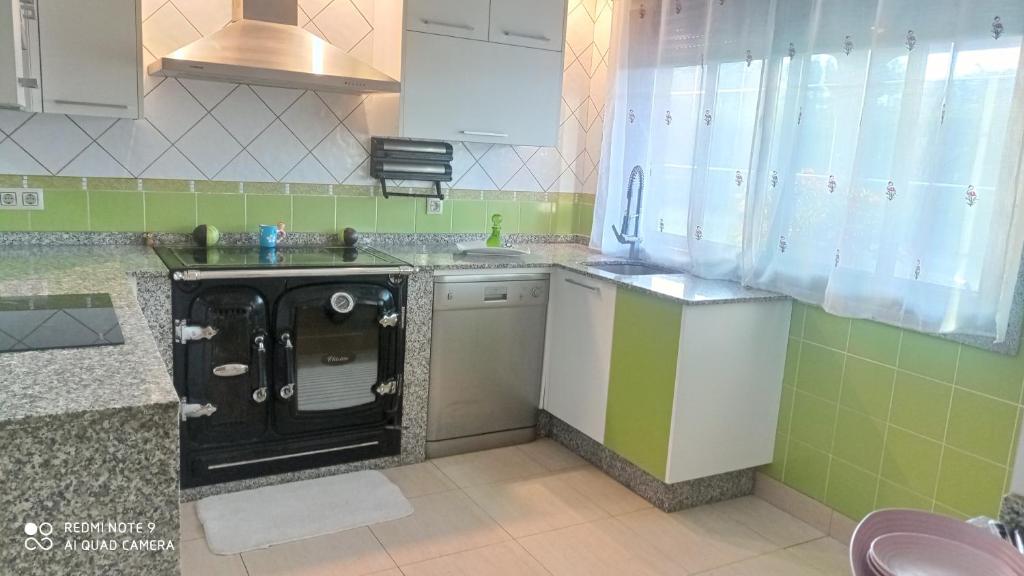 a small kitchen with a stove and a sink at A Eira de Salvador in Portas