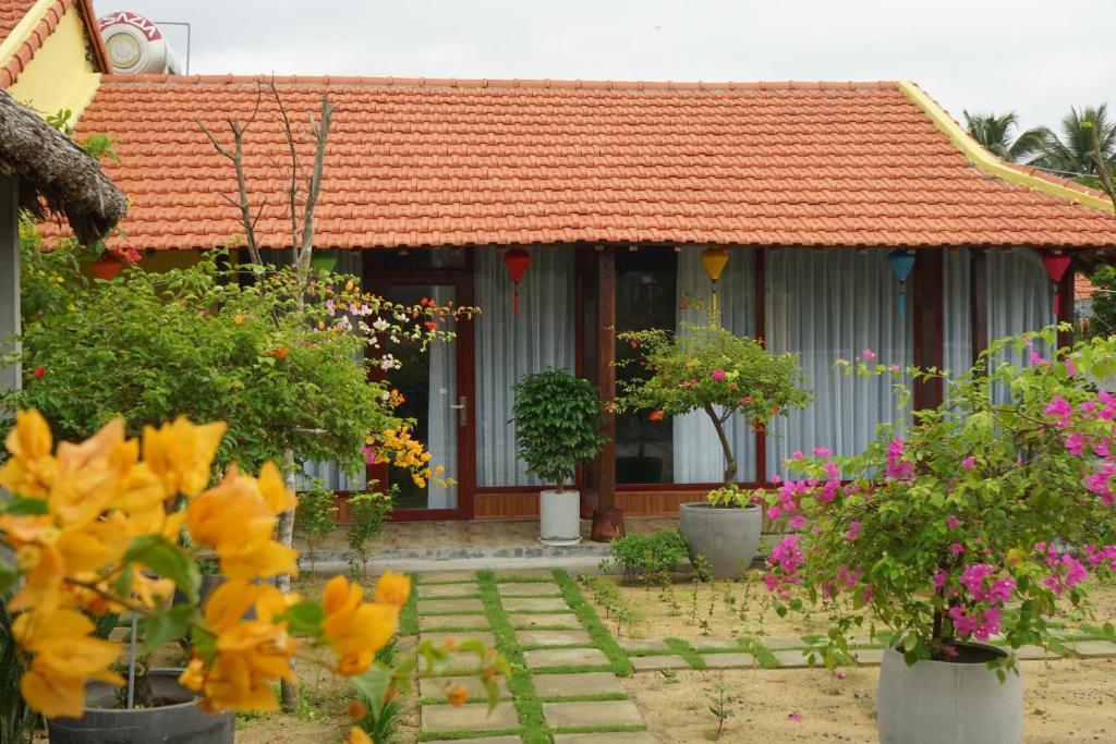 une maison avec un toit orange et quelques fleurs dans l'établissement Ngoc Lan Homestay 2, 