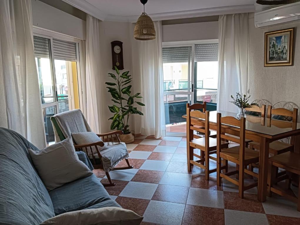 uma sala de estar com uma mesa e uma sala de jantar em Casa Delfin em Punta Umbría