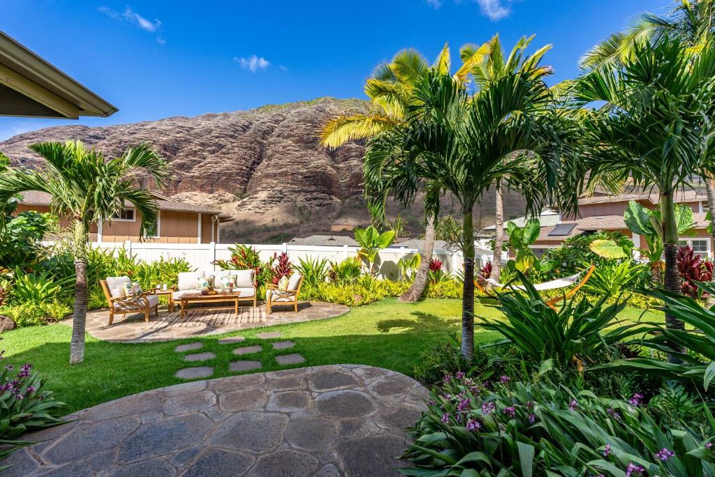 un jardín con palmeras y una montaña en el fondo en @ Marbella Lane - Pōmaika'i Ocean Love Nest, en Waianae