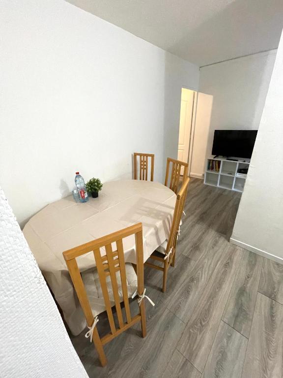 une salle à manger avec une table, des chaises et une télévision dans l'établissement Appartement 3 chambres à Troyes, à Troyes