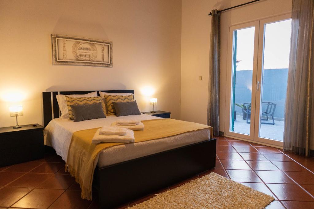 a bedroom with a bed with two towels on it at By the hill in Ribeira Grande