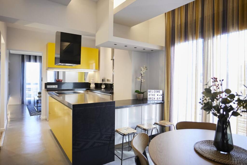 a kitchen and dining room with a table and yellow cabinets at A3_Aplotaria Architect's Apartment in Chios