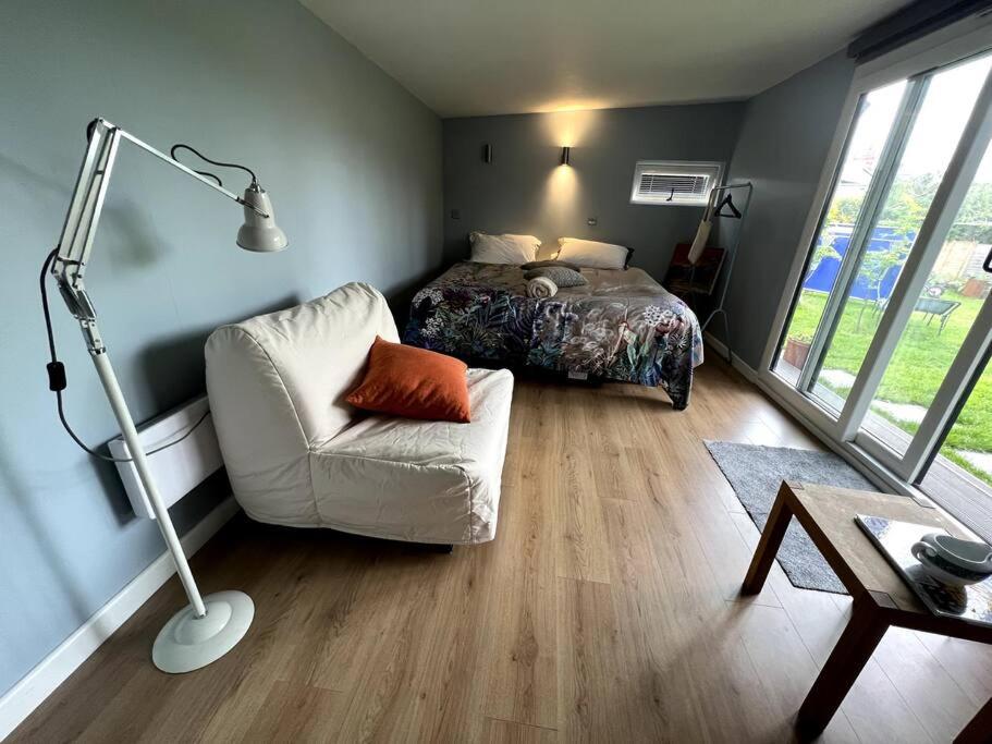 een slaapkamer met een bed, een stoel en een lamp bij Henley Garden Studio in Henley on Thames