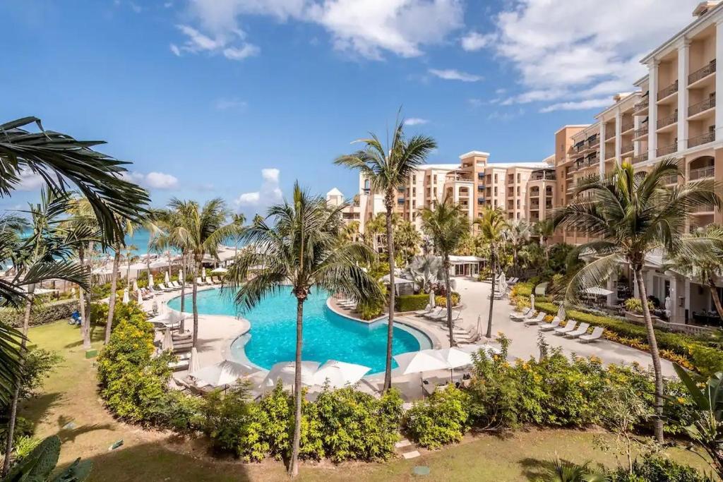 an aerial view of a resort with a pool and palm trees at Ocean View Residence 304 located at The Ritz-Carlton in Upper Land