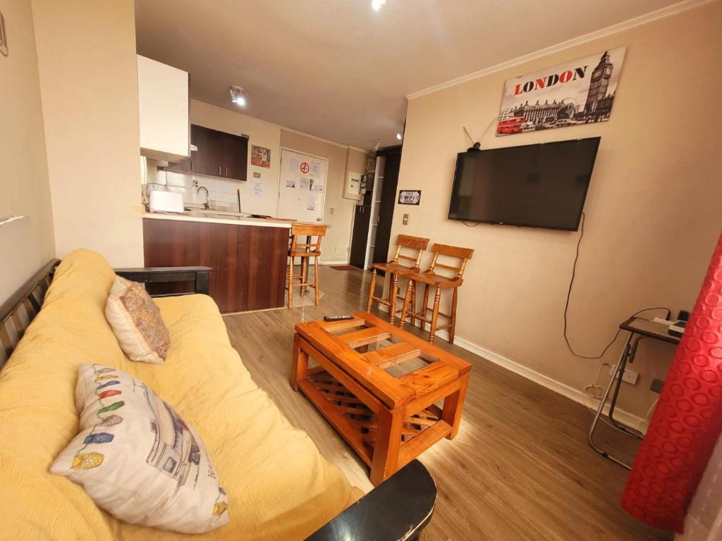 a living room with a couch and a flat screen tv at ChileRuca Departamentos Amoblados in Santiago