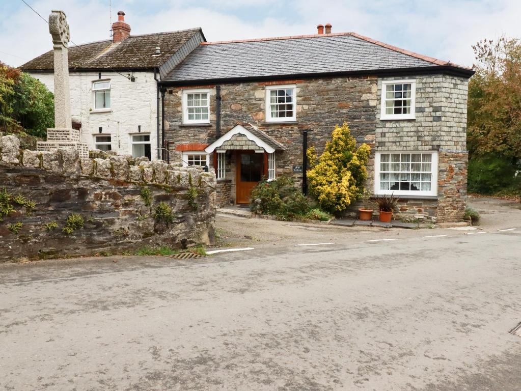 een oud stenen huis aan de kant van de weg bij Mill Cottage in Liskeard