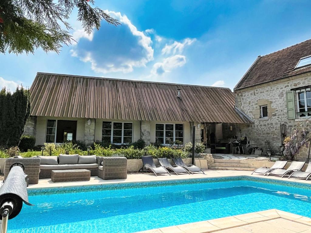 una casa con piscina frente a una casa en Relais de Poste des Templiers en Jouaignes