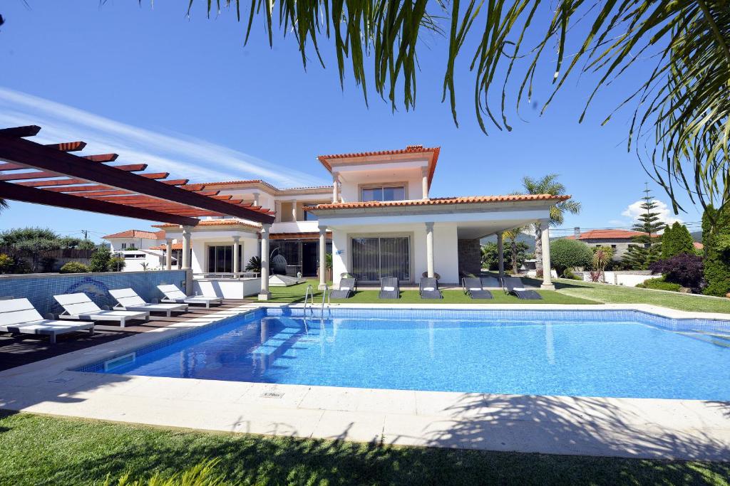 a swimming pool in front of a villa at Villa 320 in Barcelos