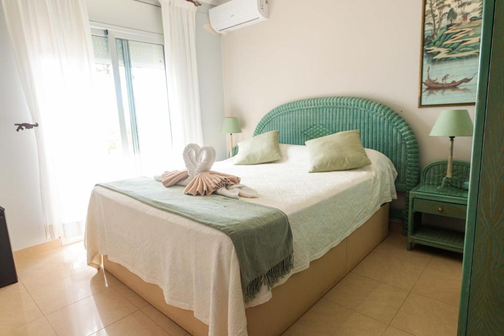 Paraíso Costa Dorada في تاراغونا: غرفة نوم مع سرير مع اللوح الأمامي الأخضر