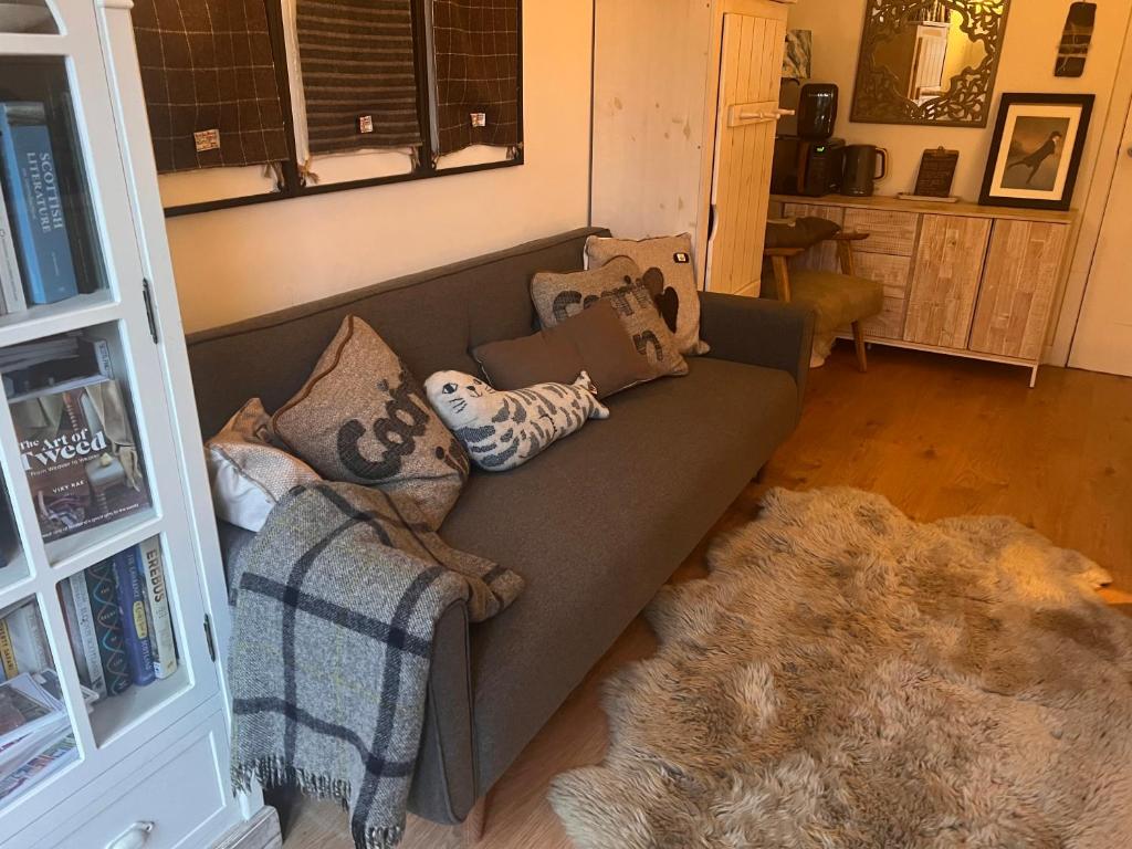 sala de estar con sofá gris con almohadas en The Coorie Inn @ Portobello, Edinburgh’s Seaside. en Edimburgo