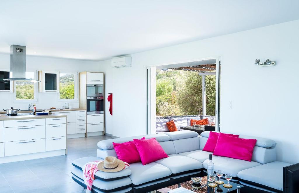 a living room with a blue couch and pink pillows at Villa Mare in Corbara