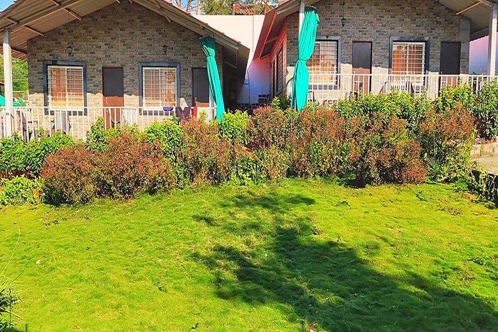 a house with a green lawn in front of it at Sunshine Resort in Pune