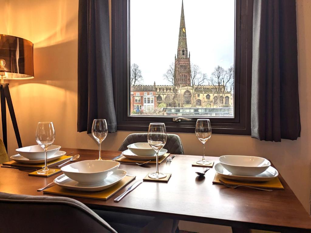 a table with wine glasses and a view of the eiffel tower at Gorgeous Modernised City Centre Apartment in Coventry