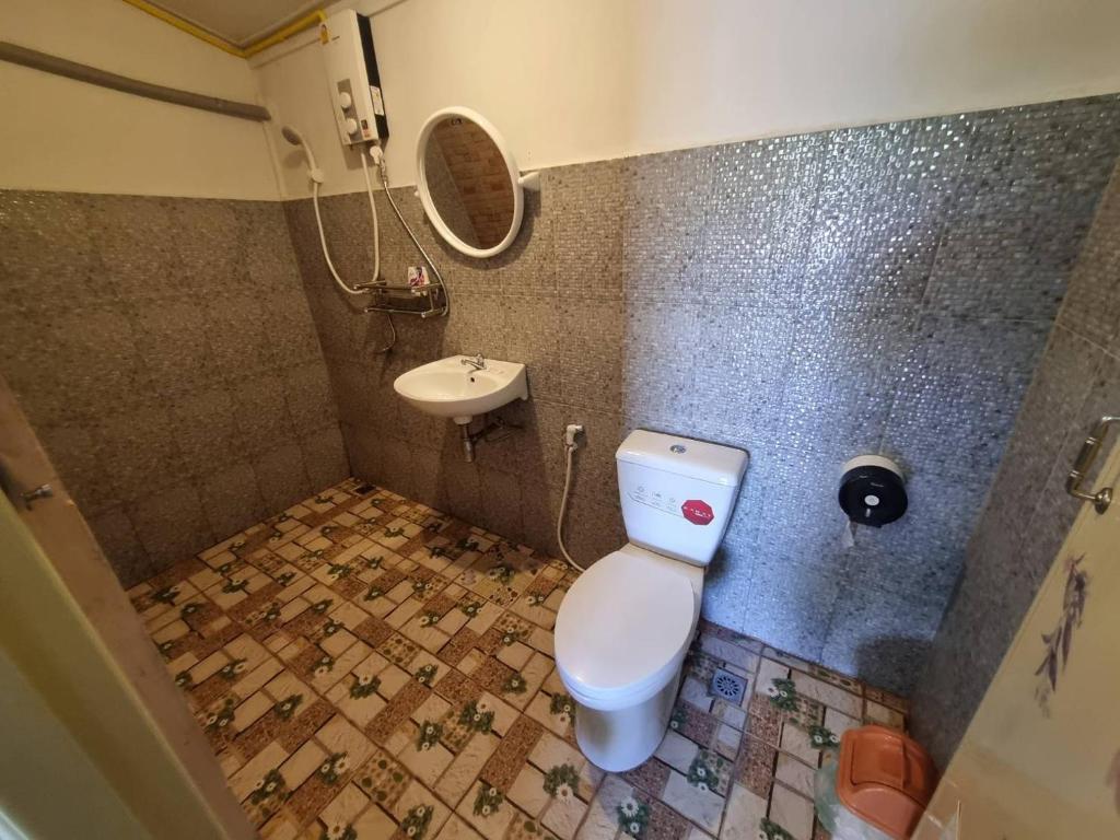 a bathroom with a toilet and a sink at บ้านสวน สระแก้ว รีสอร์ท 