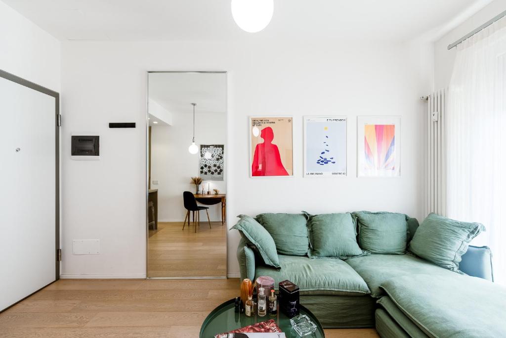 sala de estar con sofá verde y mesa en Appartamenti in Centro - Biancospino Apartments, en Milán