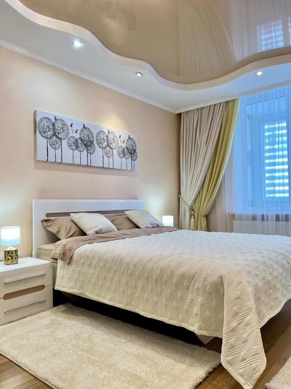 a bedroom with a large bed and a large window at Чудова квартира поруч з парком in Ternopilʼ