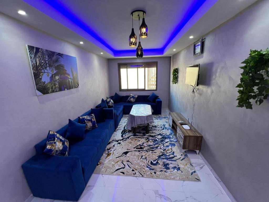 - un salon avec un canapé bleu et une table dans l'établissement Appartement Jardins de Tanger , 2 chambres, à Tanger