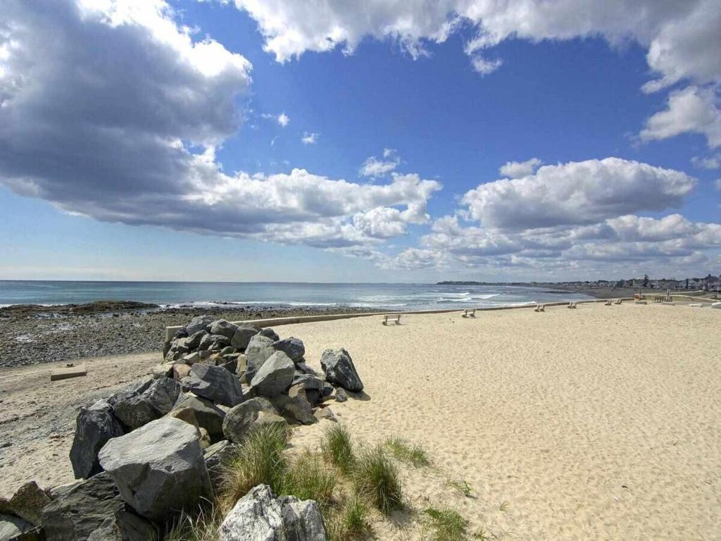 een strand met rotsen op het zand en de oceaan bij Beach Cottage on North Beach in Hampton