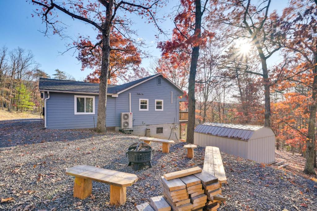 une arrière-cour avec bancs et une maison dans les bois dans l'établissement Serene Springfield Retreat on 6 Acres with Hot Tub!, à Springfield