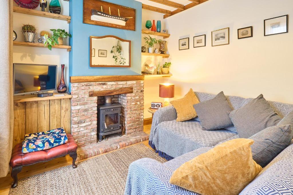 sala de estar con sofá y chimenea en Host & Stay - Ethelbert Cottage en Broadstairs