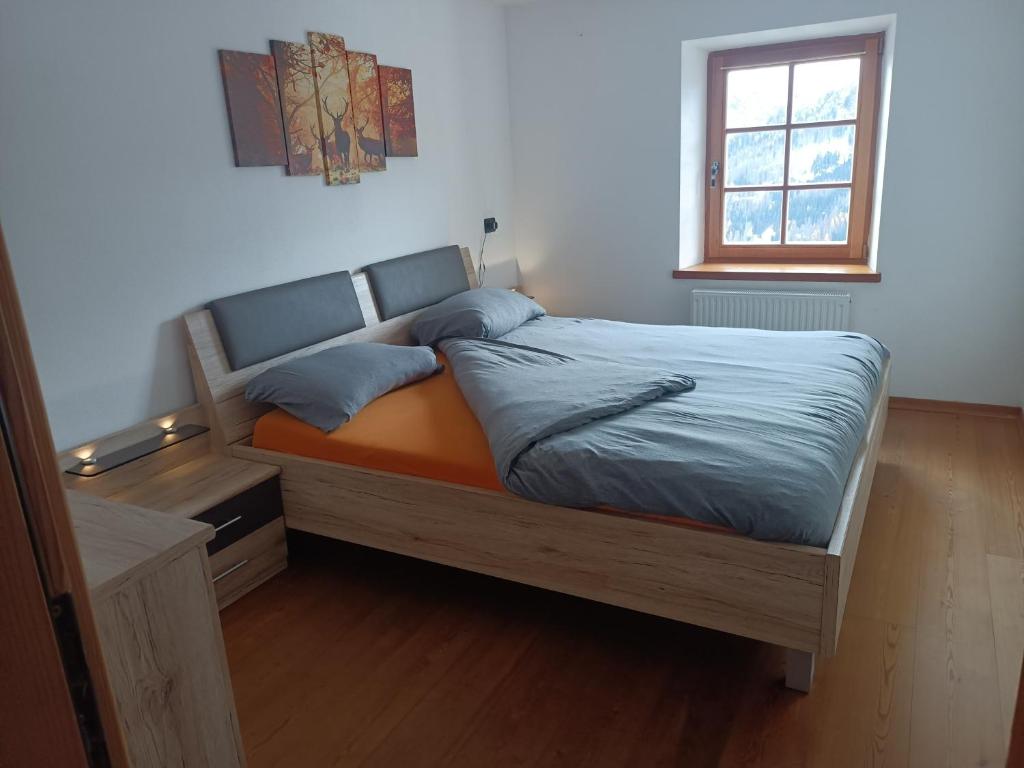 een bed in een slaapkamer met een raam bij Appartamento Robert Arabba in Livinallongo del Col di Lana