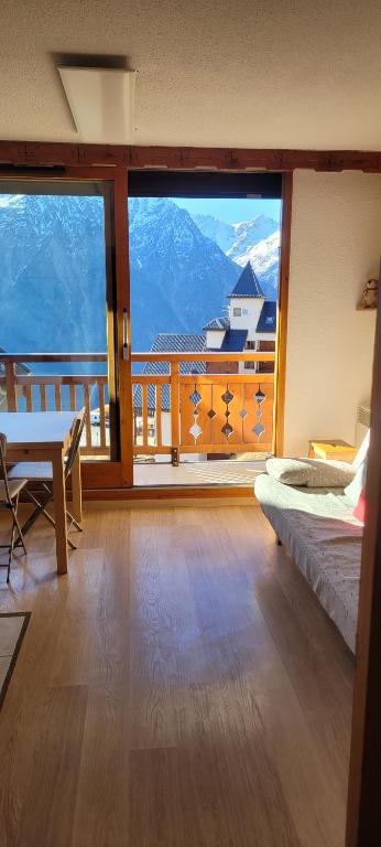 a room with a balcony with a view of a mountain at Appartement les 2 Alpes avec vue sur la muzelle in Vénosc