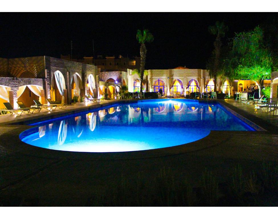 a large swimming pool in a building at night at RS Hotel Karam Palace in Ouarzazate
