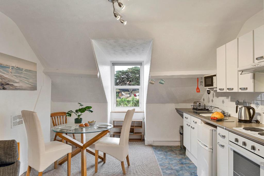 a kitchen with a table and chairs and a window at Finest Retreats - Atherfield Apartments No 8 - Roof Tops in Paignton