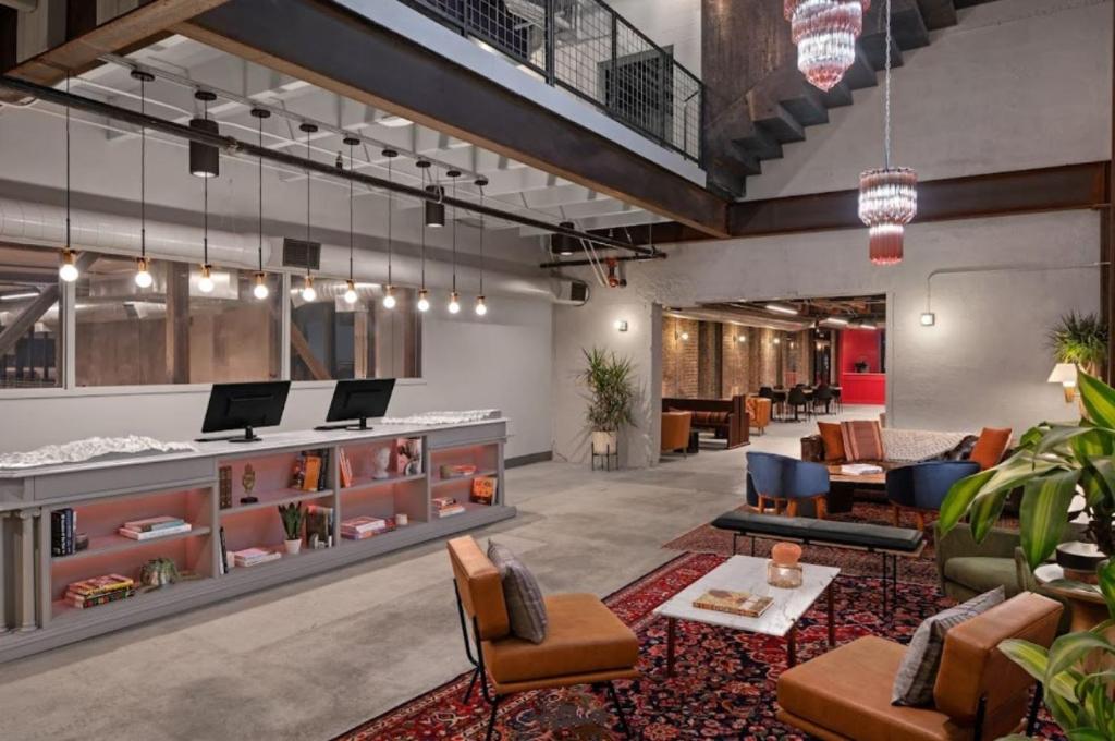 a lobby with a waiting area with chairs and tables at Bposhtels SLC in Salt Lake City