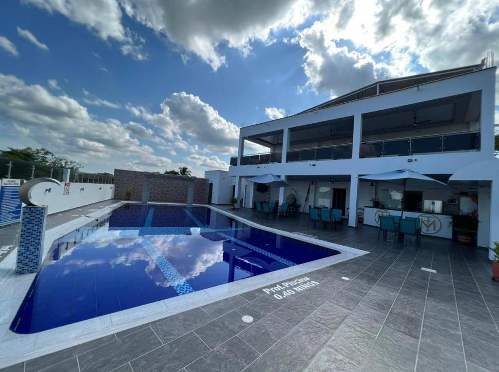 a building with a swimming pool in front of a building at HOTEL MASS LUXURY in Doradal