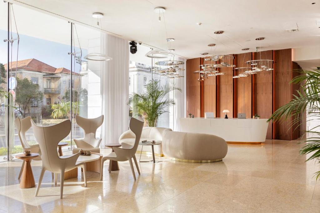 a dining room with chairs and a table and windows at EVOLUTION Cascais-Estoril Hotel in Estoril