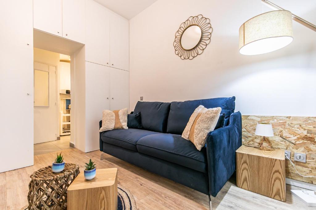 un salon avec un canapé bleu et une table dans l'établissement MBA Splendide Appart - Parmentier - Paris - Proche Bastille, à Paris