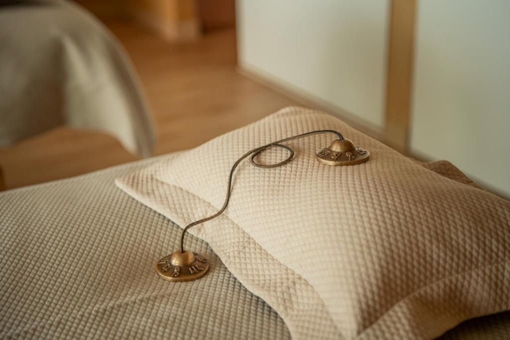 a pair of earrings sitting on top of a pillow at EVOLUTION Cascais-Estoril Hotel in Estoril