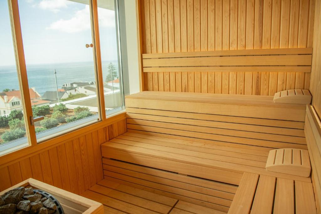 a wooden sauna with two chairs and a window at EVOLUTION Cascais-Estoril Hotel in Estoril