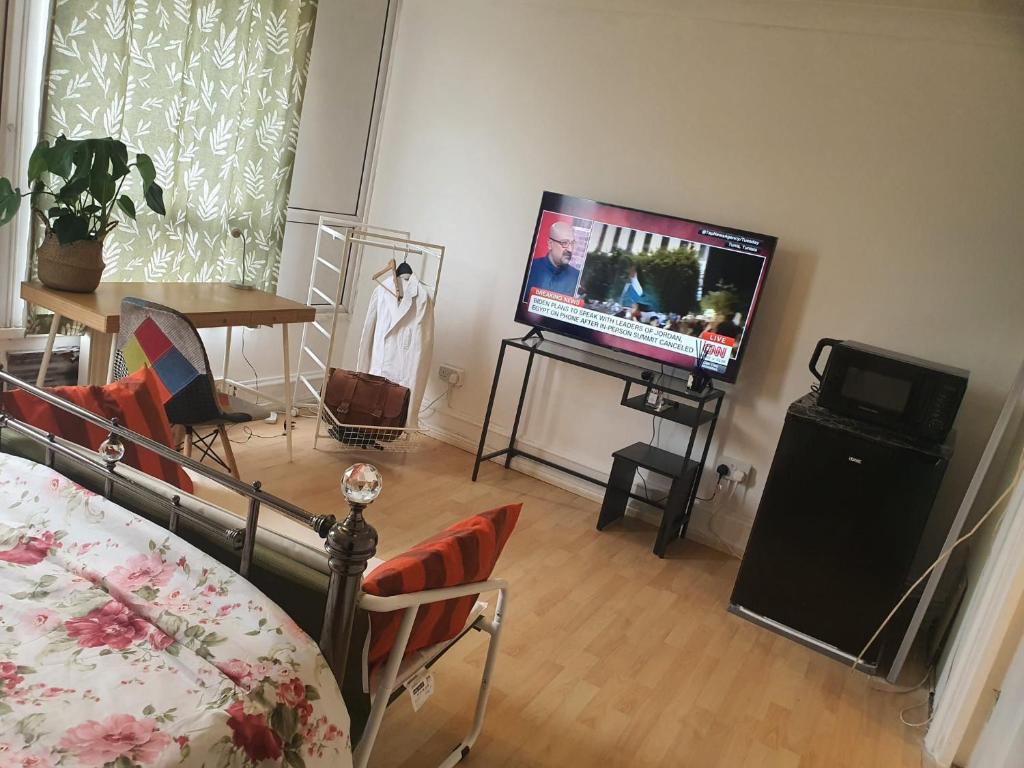 uma sala de estar com uma televisão de ecrã plano num suporte em BluepointPH em Abbey Wood