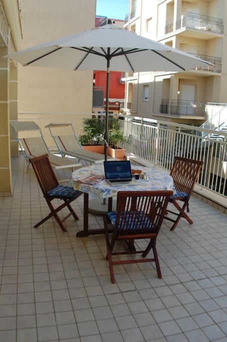 a table and chairs with a laptop on a patio at Souvenir 6 in Gabicce Mare