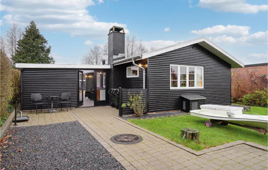 una pequeña casa negra con patio trasero en Gorgeous Home In Hornslet With Kitchen en Hornslet