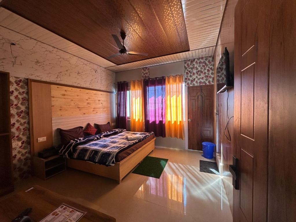 een slaapkamer met een bed en een raam met gordijnen bij Kanatal's Valley View INN in Kanatal