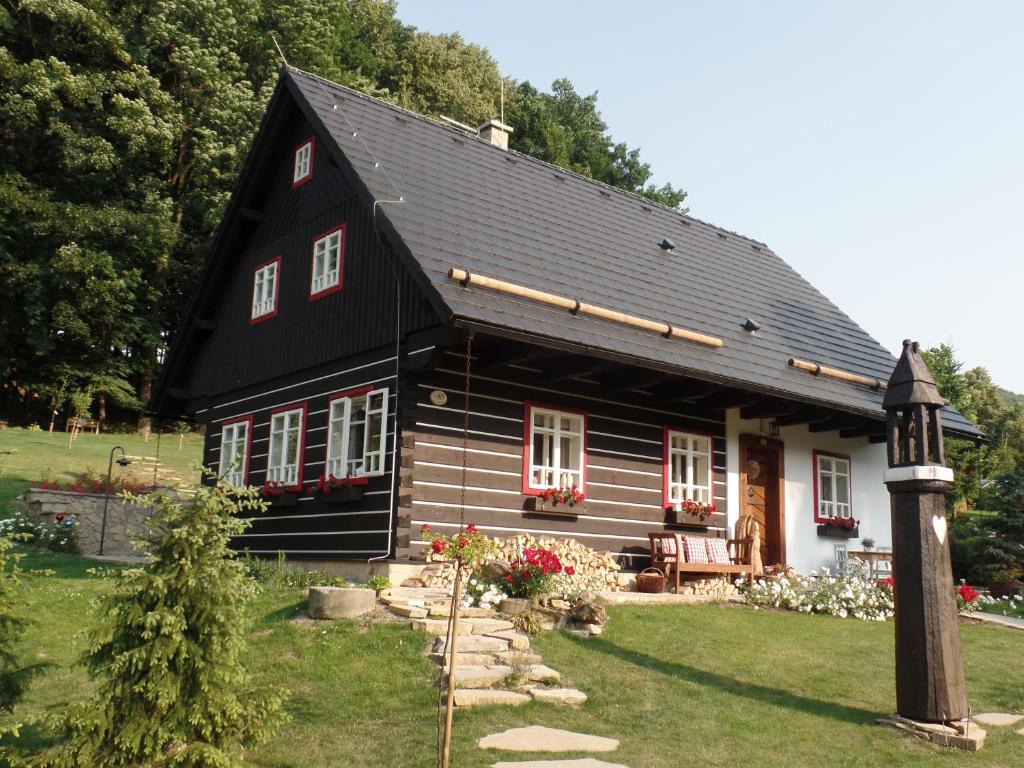 a black house with a black roof at Penzion Roubenka in Hukvaldy