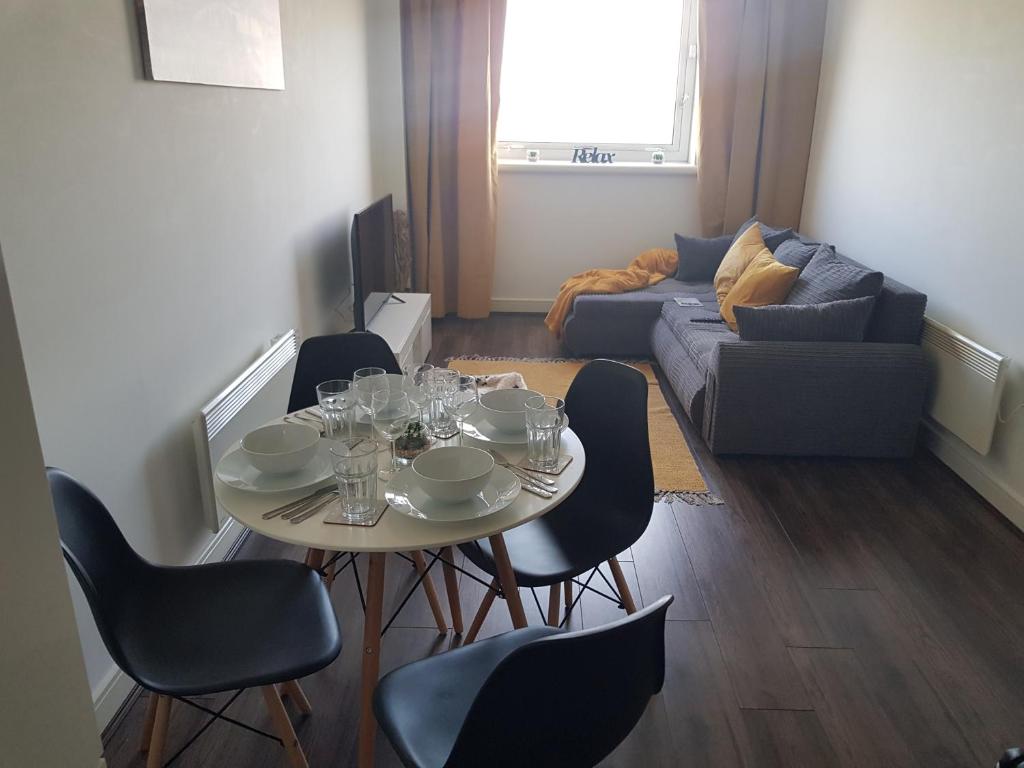 ein Wohnzimmer mit einem Tisch, Stühlen und einem Sofa in der Unterkunft Stunning 1-Bed Apartment in Brierley Hill in Dudley